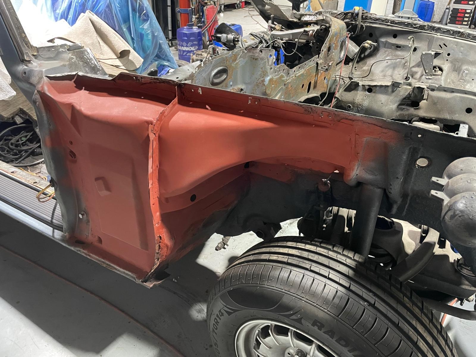 Detailarbeit an freigelegter Karosserie im Motorraum