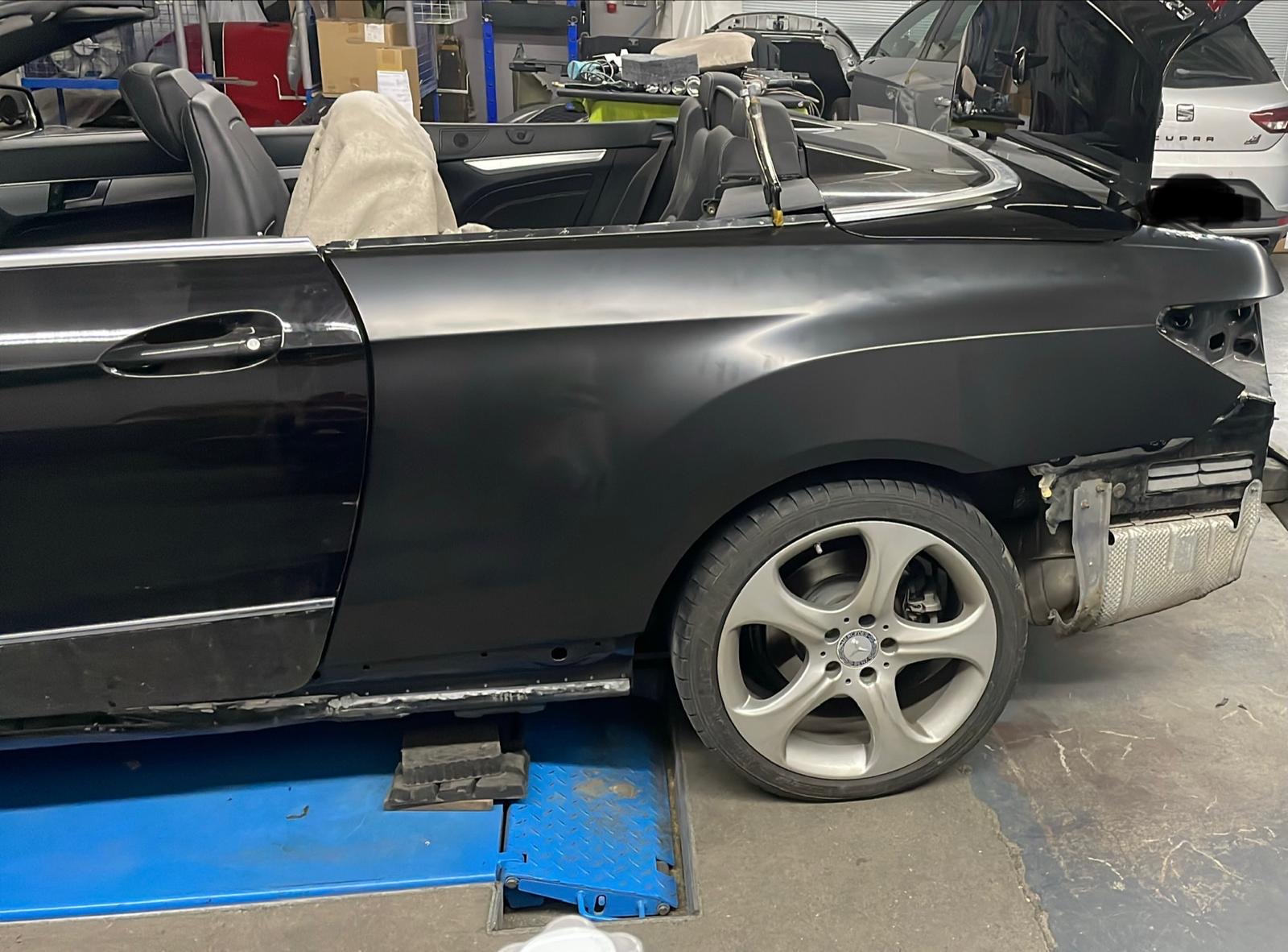 Schwarzes BMW Cabrio während Reparatur auf Hebebühne