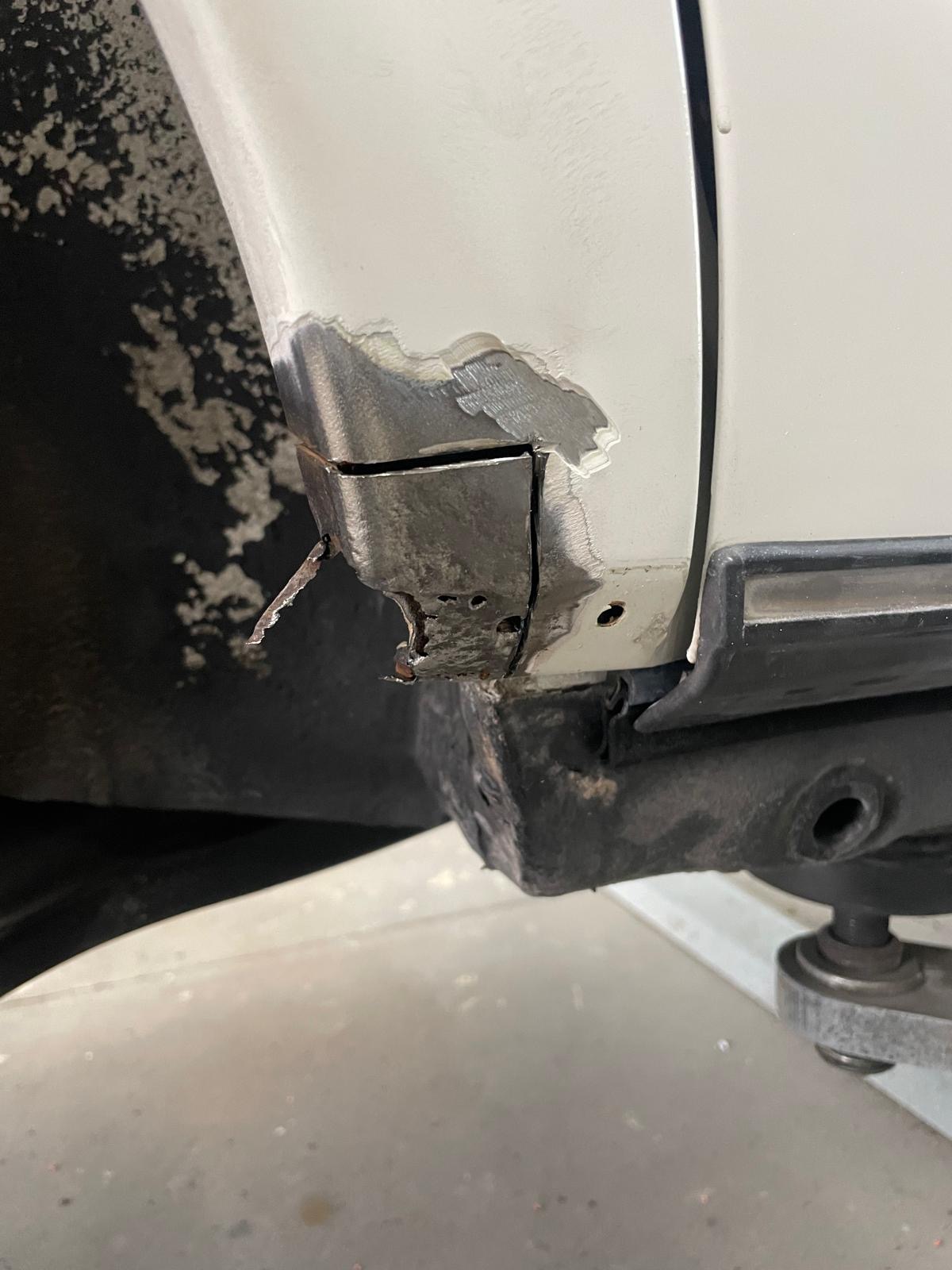 Aufgerissener Schweller mit Rost am weißen Auto