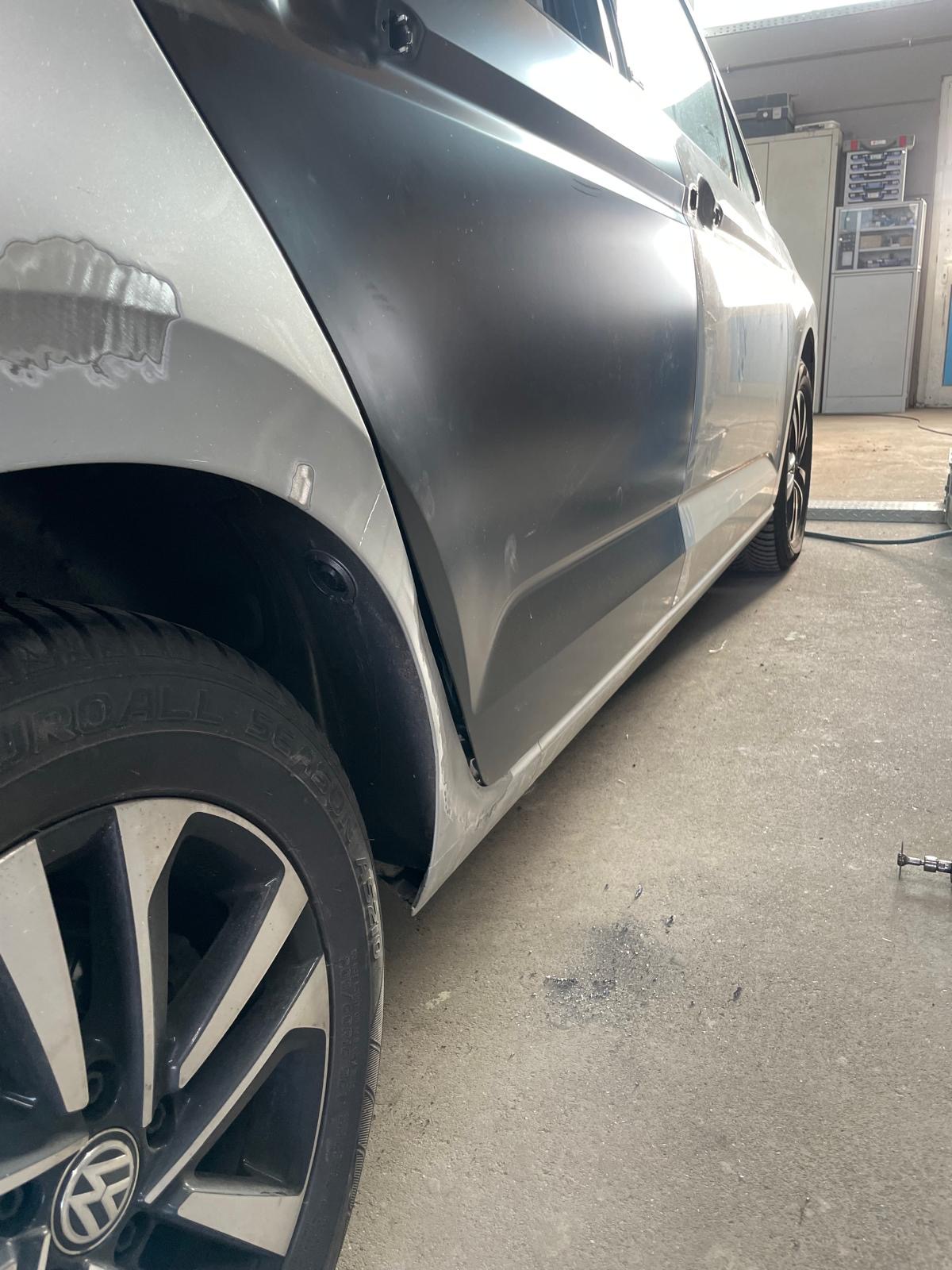 Silberner VW Polo mit Beule am Heck und Tür