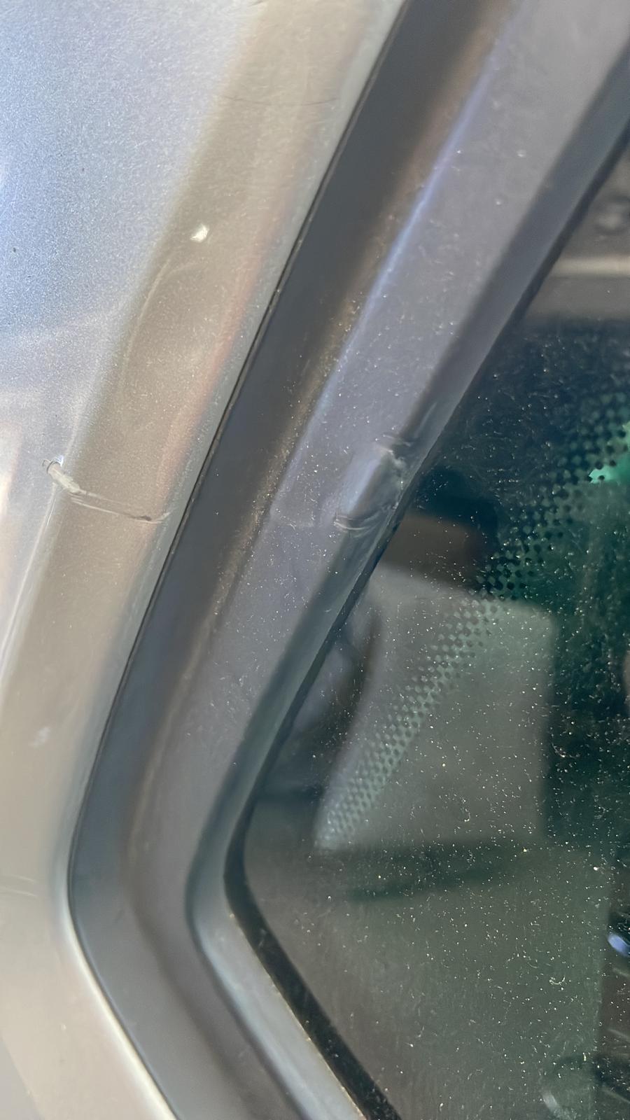Detail des Türrahmens mit Schweißpunkten am silbernen Auto während der Verglasungs-Vorbereitung
